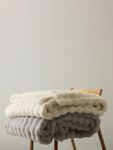 Soft handloom blankets folded on wooden stool