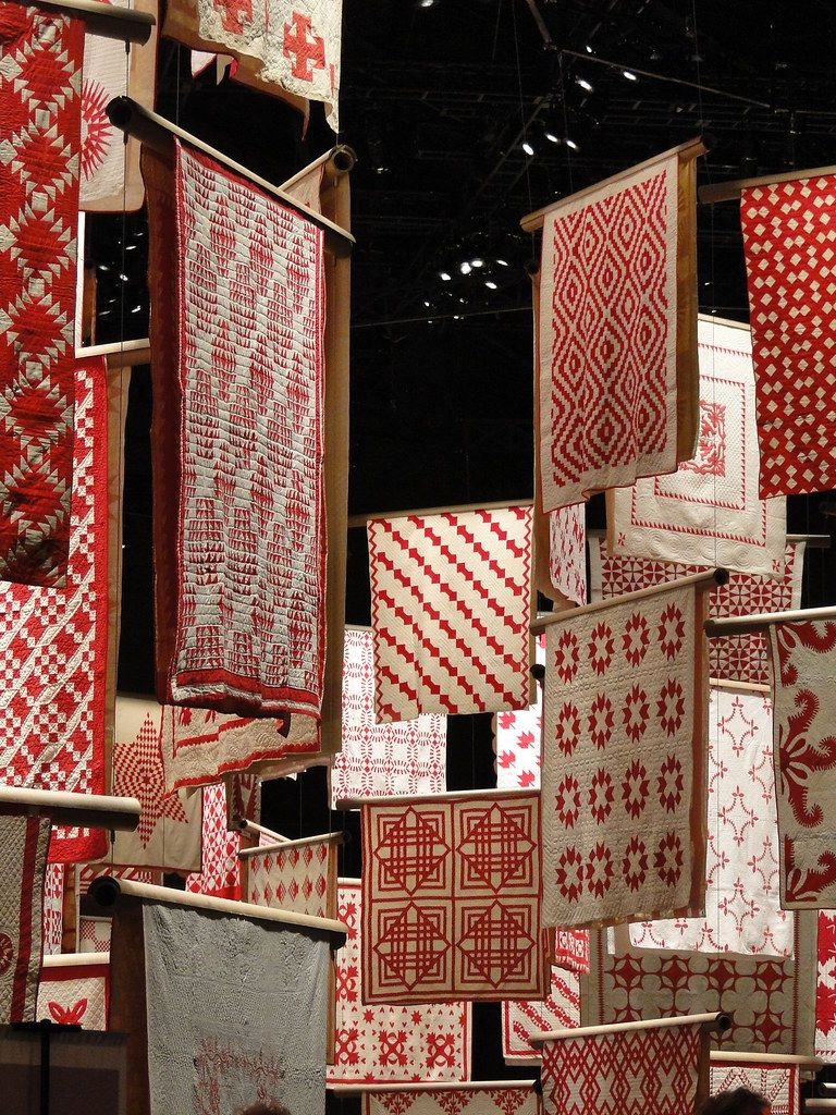 Display of handwoven red and white quilts and textiles